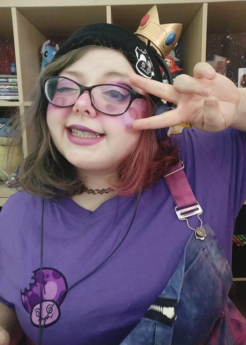Frau mit Brille trägt lila Rotten Mushroom t-Shirt und Mütze